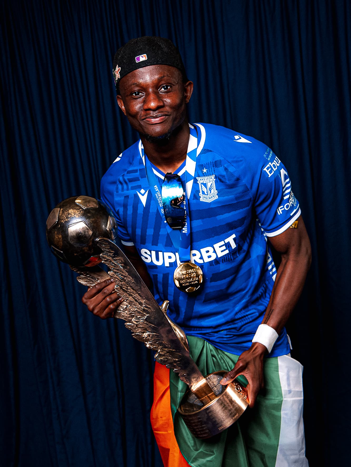 Yannick Agnero holding the Ekstraklasa trophy with his championship medal